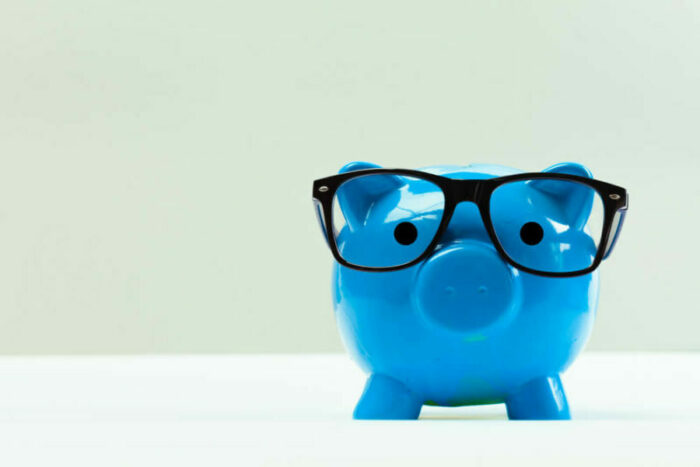 Blue piggy bank wearing glasses