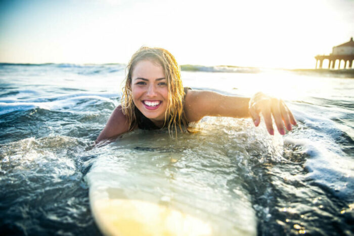 Young woman on surfboard in ocean