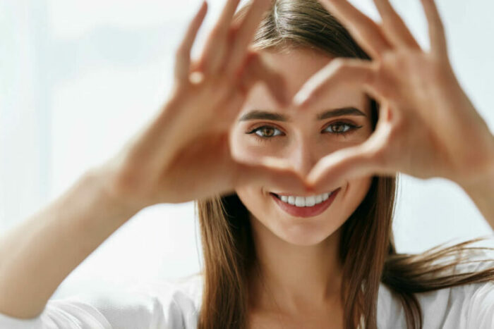 Young woman making a heart with her hands